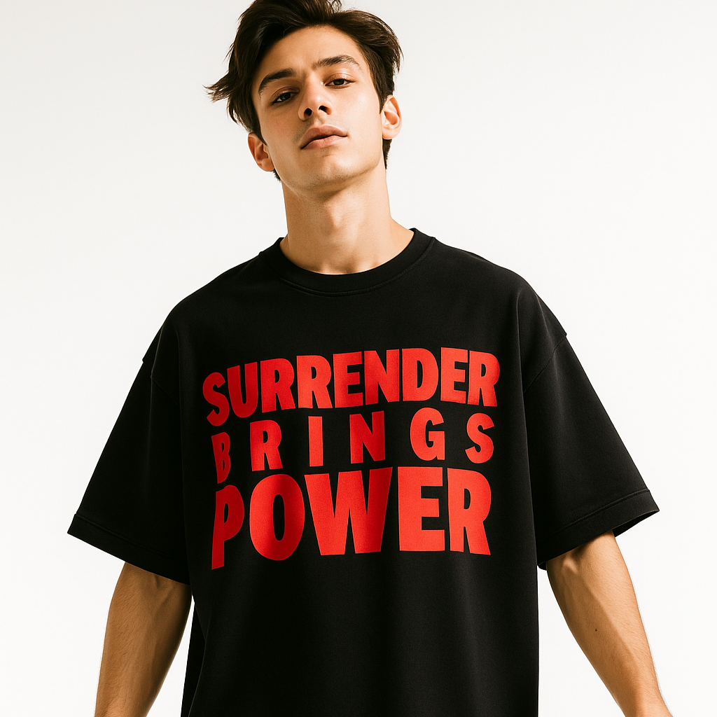 Person wearing a black t-shirt with red text 'SURRENDER BRINGS POWER' on a white background