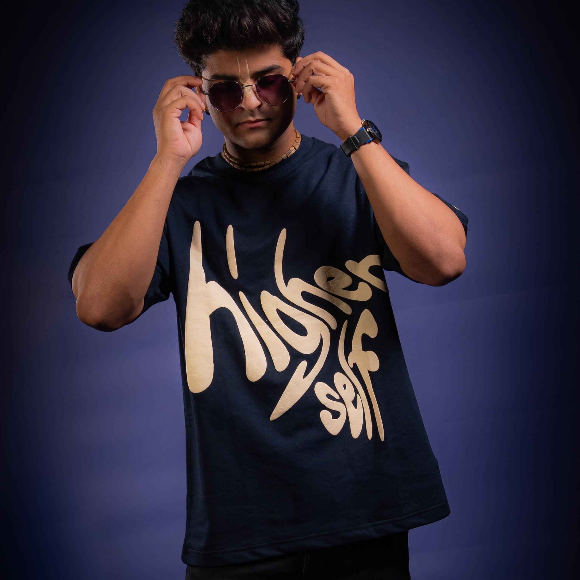 Person wearing a navy blue t-shirt with 'Higher Self' text on a dark background