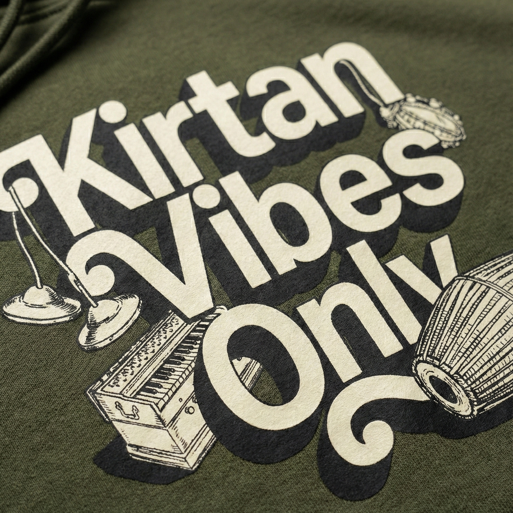 Green sweatshirt with 'Kirtan Vibes Only' text and musical instrument graphics.
