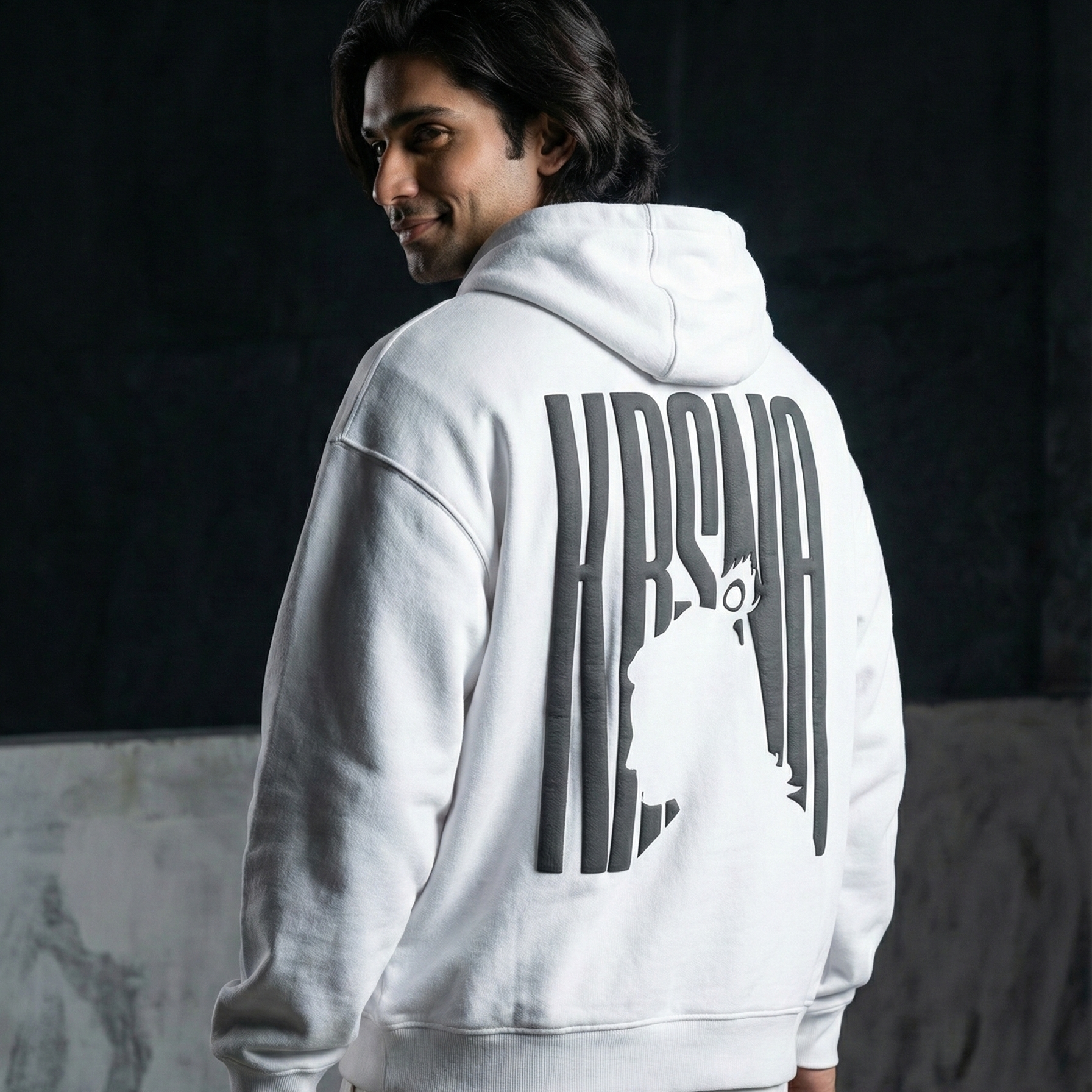 Person wearing a white hoodie with text on the back against a dark background