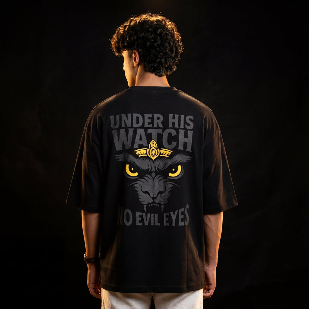 Person wearing a black t-shirt with a graphic design and text on the back against a dark background