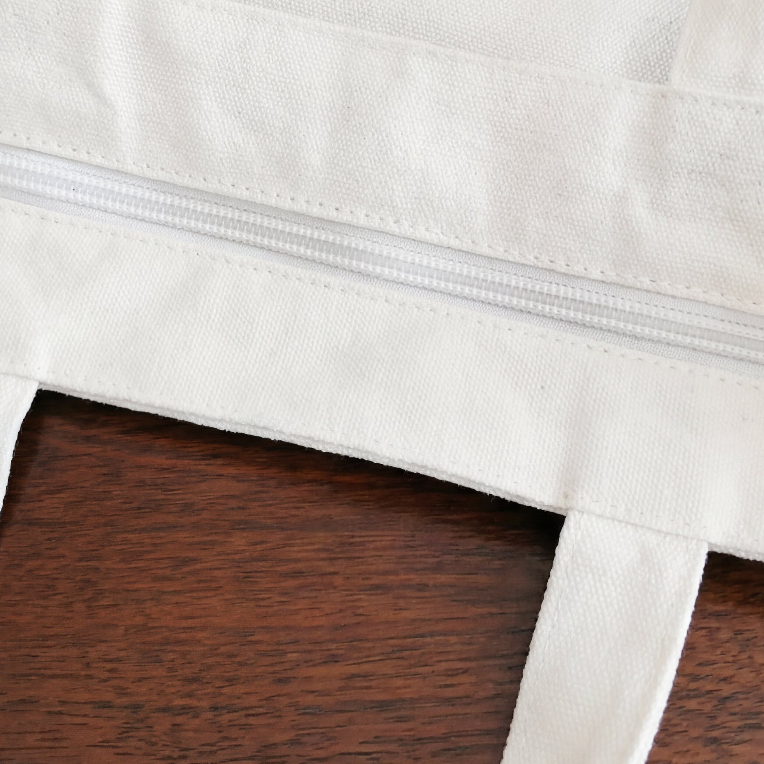 White bag with floral designs and text on a wooden surface