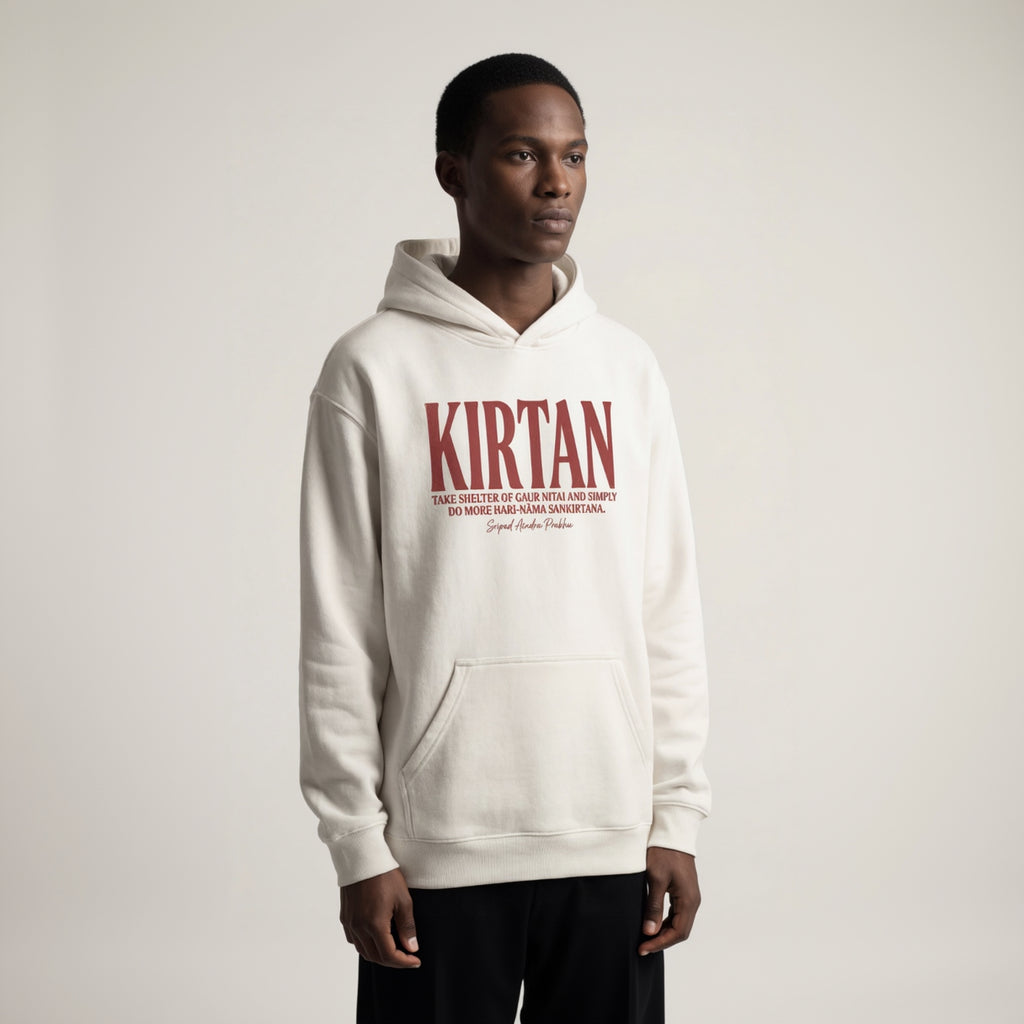 Person wearing a white hoodie with 'Kirtan' text on a plain background