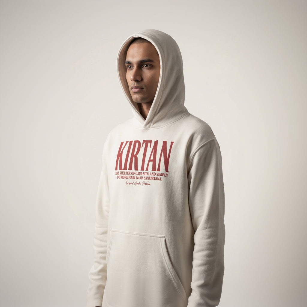 Person wearing a white hoodie with 'Kirtan' text on a plain background