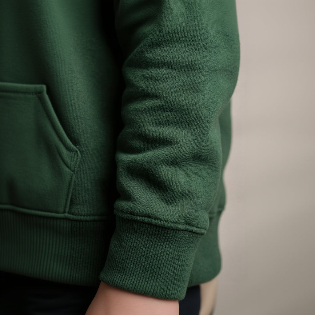 Close-up of a green sweater sleeve on a neutral background