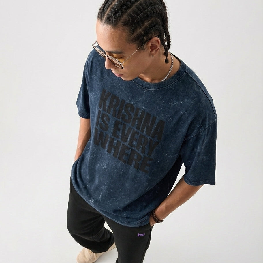 Person wearing a blue t-shirt with text, standing against a white background