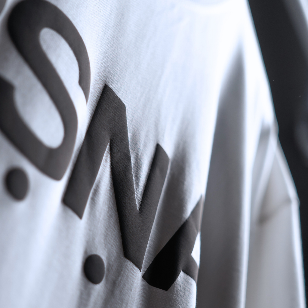 Close-up of a white shirt with black text on a blurred background