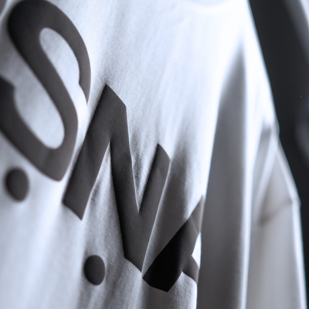 Close-up of a white shirt with black text on a blurred background